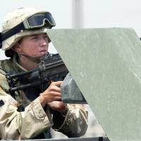 A female U.S. soldier manning a machine gun on a vehicle during clashes in the northern Iraqi city of Mosul in 2003. U.S. Defense Secretary Ash Carter said Thursday he is ordering the U.S. military to open up all positions — including combat roles — to women. | AFP-JIJI