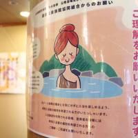 A poster urging understanding toward women with bathing wear covering surgical scars is seen at an inn in the city of Yamaguchi. | KYODO