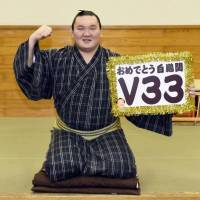 Yokozuna Hakuho displays a  placard after winning his 33rd career championship the New Year Grand Sumo Tournament in 2015, surpassing the record of 32 titles he shared with sumo legend Taiho. | KYODO