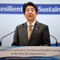 Prime Minister Shinzo Abe makes a speech at the opening of the International Conference on Universal Health Coverage (UHC) and the 5th Replenishment Preparatory Meeting of the Global Fund to Fight AIDS, Tuberculosis and Malaria in Tokyo on Wednesday. | AFP-JIJI