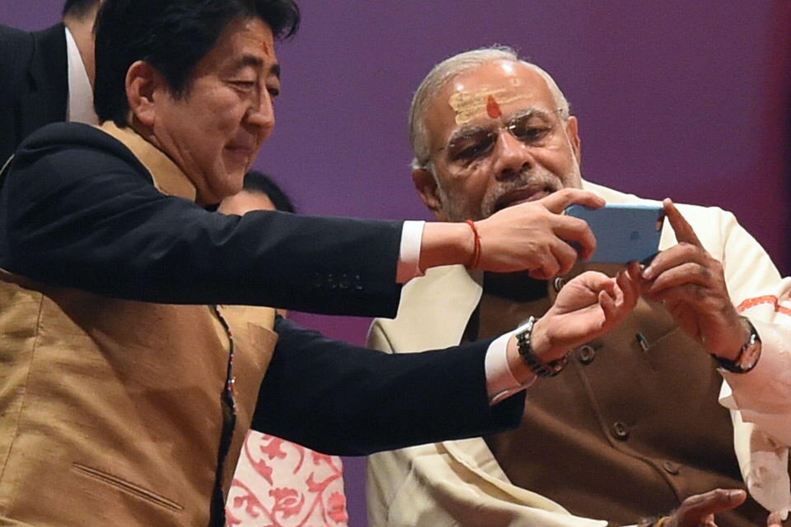Prime Minister Shinzo Abe and Indian Prime Minister Narendra Modi take a photo together on a mobile phone on the banks of the River Ganges in Varanasi, India, on Saturday. | AFP-JIJI