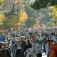 Visitors enjoy walking along Inui Road on the Imperial Palace grounds in Tokyo on Saturday. | KYODO
