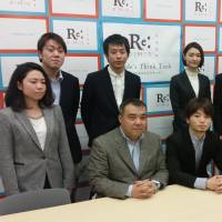 Aki Okuda (seated, center) and other members of Students Emergency Action for Liberal Democracy (SEALDs) announce the launch of a new think tank, ReDemos, in Tokyo on Monday. Seated at left is Koichi Nakano, a political science professor at Sophia University, and seated at right is attorney Takahisa Mizukami. | TOMOHIRO OSAKI