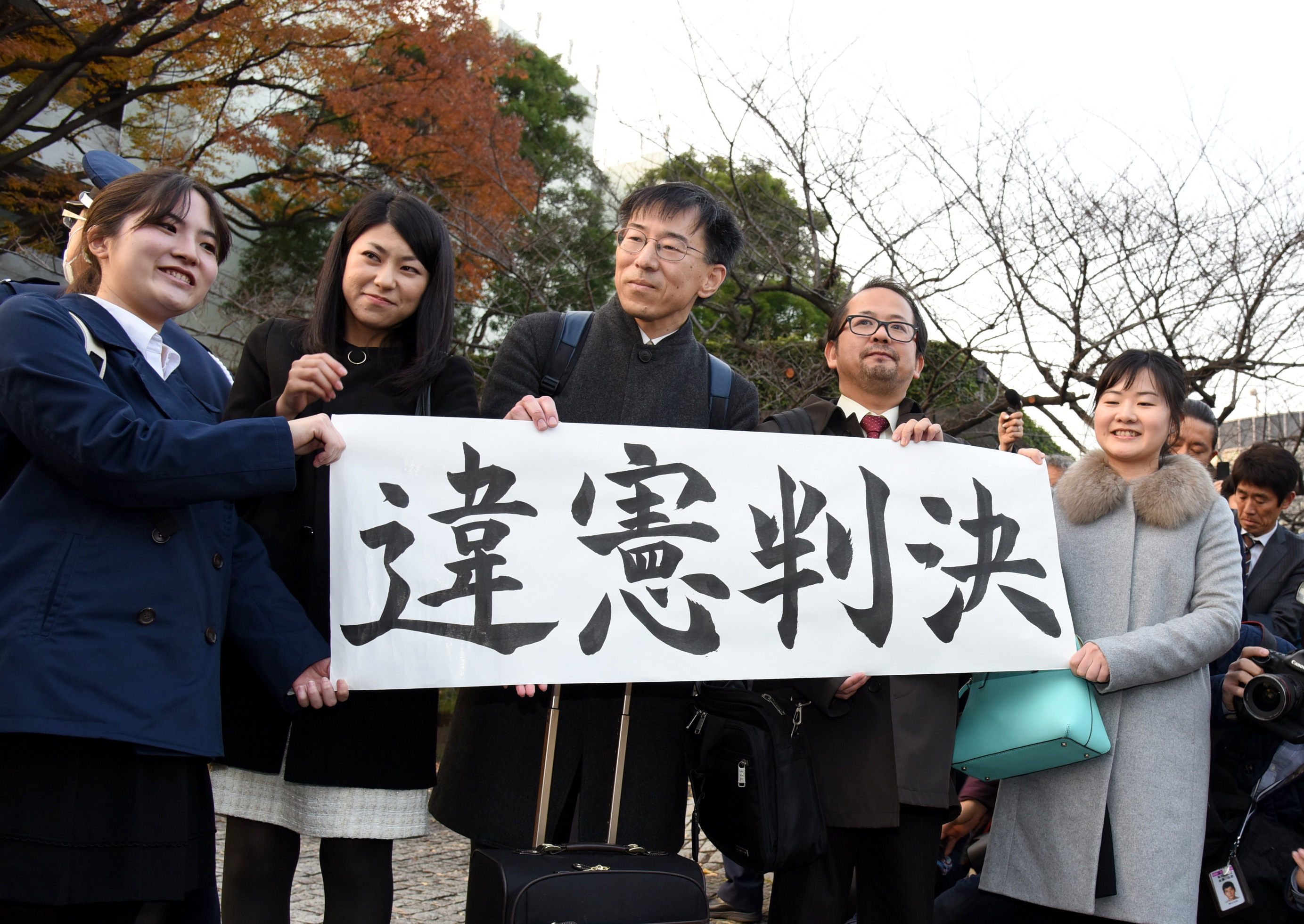 Supporters of a lawsuit challenging a six-month ban on remarriage for female divorcees hold a banner reading 'Unconstitutional ruling' after the Supreme court's decision. | SATOKO KAWASAKI