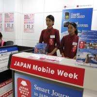 Kicking off a one-month campaign, Japan Tourism Agency staff promote the use of SIM cards for tourists at Narita International Airport on Monday. | KAZUAKI NAGATA