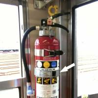 A fire extinguisher similar to this one fell and released its contents during the morning rush hour on the Hanzomon Line of the Tokyo subway. Police are investigating whether someone removed the restraining band, indicated. | TOKYU CORP. / KYODO