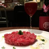 Desnoyer\'s classic steak tartare is a perfectly formed disk of red sirloin, seasoned expertly and simply garnished with a small scattering of spring onion.  | ROBBIE SWINNERTON