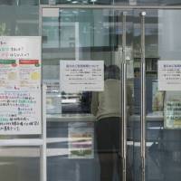 Willing to work: A man makes an inquiry at a senior work placement corner inside Tokyo Shigoto Center on Nov. 30. | ROB GILHOOLY