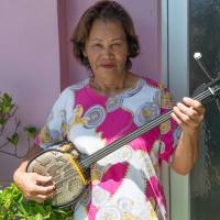 Friendly fare: Tsukasa Maeda, owner of the Iheya Kanko Hotel, holds a sanshin, the iconic Okinawan instrument. | STEPHEN MANSFIELD