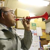 Shigeyuki Hasegawa, owner of Nippon Kyoiku Gakki Co. Ltd. toots his horn. | KIT NAGAMURA