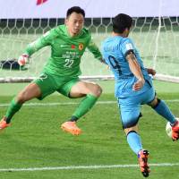 Barcelona\'s Luis Suarez scores past Guangzhou Evergrande goalkeeper Li Shuai in their Club World Cup semifinal match in Yokohama on Thursday night. Barcelona won 3-0. | AFP-JIJI