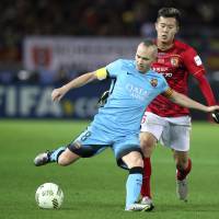 Barcelona\'s Andres Iniesta (left) controls the ball in front of Guangzhou Evergrande\'s Huang Bowen on Thursday. | AP