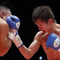 Ryoichi Taguchi (right) punches Luis de la Rosa during their WBA light flyweight title bout on Thursday. | REUTERS