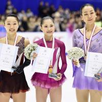 Winner Satoko Miyahara (center) stands with runnerup Wakaba Higuchi and third-place finisher Mao Asada on Sunday in Sapporo. | KYODO
