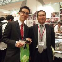 Yoshichika Terasawa (right), of the Japan Halal Expo 2015 executive committee and special advisor to Makuhari Messe Inc. poses with exhibitor Junya Machiya, president of Tenmabayashi Ryutukako from Aomori Prefecture at the event, which saw 67 exhibitors participate, at Makuhari Messe, Chiba Prefecture. | EDLEEN OTHMAN