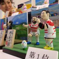 Dolls known as hina, featuring people who made headlines this year, are displayed Wednesday at Saitama-based doll-maker Togyoku. On the right is a representation of rugby star Ayumu Goromaru in his trademark concentration pose. | KYODO
