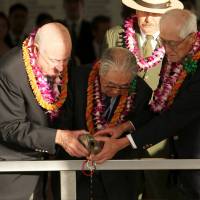 Former U.S. B-25 pilot Jack DeTour (left), Dr. Hiroya Sugano (center) and former Japanese fighter pilot Shiro Wakita pour bourbon into the \"Remembrance Well\" at the USS Arizona Memorial during the \"Blackened Canteen\" ceremony in Honolulu on Sunday during commemorations for the 74th anniversary of the attack on Pearl Harbor. Story: Page 2 | REUTERS