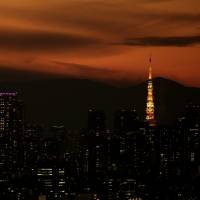 Mount Fuji is silhouetted against the Tokyo skyline. The tumbling number of property transactions has prompted analysts to turn bearish on property prices. | BLOOMBERG