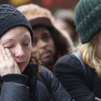 Bianca Soto wipes a tear from her eye while she pays her respects at the New York memorial. | AP