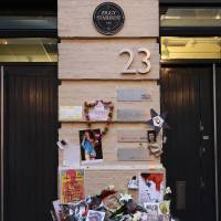 Flowers are left beneath a plaque marking the location of the cover photo for Bowie’s \"Ziggy Stardust\" album in central London, Jan. 13. | AFP-JIJI