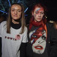 Two young fans in the crowd wear Bowie merchandise and Ziggy Stardust face makeup in his honor. | AFP-JIJI