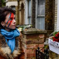 Another woman with her face painted like Ziggy Stardust pays her respects outside a house believed to be the childhood home of David Bowie in Brixton, south London. | AFP-JIJI
