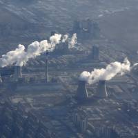 Chimneys from a power plant emitting smog are pictured from a plane on the outskirts of Beijing on Friday. | REUTERS