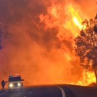 Firefighters battle a massive blaze near Yarloop in Western Australia on Thursday. | AFP-JIJI