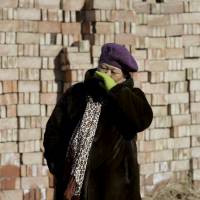 Manager Han Fengge stands outside her closed brick factory in a village on the outskirts of Beijing on Jan. 18. | REUTERS