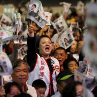 Supporters of Democratic Progressive Party leader and presidential candidate Tsai Ing-wen wave flags during a campaign rally in Douliu, Taiwan, on Monday. | REUTERS