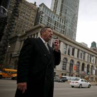 U.S. Republican presidential candidate Michael Petyo leaves a voice message while campaigning in downtown Chicago last November. | REUTERS