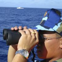 A Vietnamese coast guard crewman looks out to sea as Chinese coast guard vessels chased Vietnamese ships that came near the Haiyang Shiyou 981 oil rig in the South China Sea in July 2014. | REUTERS