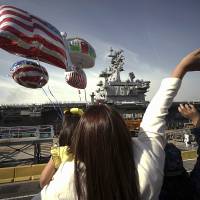 Family members of sailors wave as the U.S. Navy aircraft carrier USS Ronald Reagan arrives Oct. 1 at a U.S. Navy base in Yokosuka, Kanagawa Prefecture. The U.S. Pacific Fleet is smaller than it was in the 1990s, helping fuel a debate about whether the U.S. has enough ships to meet challenges posed by fast-growing and increasingly assertive Chinese naval forces. | AP
