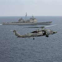 A U.S. Navy helicopter lands Oct. 17 on the deck of the U.S. Navy aircraft carrier USS Theodore Roosevelt as the USS Normady sails nearby during Exercise Malabar 2015 about 150 miles off Chennai, India. | AP