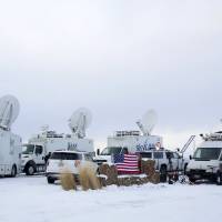 Media and satellite trucks are seen at the Malheur National Wildlife Refuge near Burns, Oregon, Monday. | REUTERS