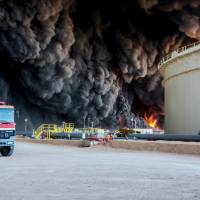 Fire rises from an oil tank in the port of Es Sider, in Ras Lanuf, Libya, Jan. 6. A blast ripped through a pipeline at a nearby complex Thursday and sabotage is suspected. | REUTERS