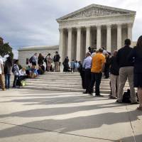 People line up outside of the Supreme Court in Washington on Oct. 13 as the justices began to discuss sentences for young prison “lifers.” In a decision in Montgomery v. Louisiana, the court ruled Monday that people serving life terms for murders they committed as teenagers must have a chance to seek their freedom. U.S. top court bars automatic life terms for crimes committed by teens