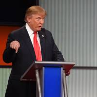 Republican presidential candidate Donald Trump (left) speaks while fellow candidate Sen. Ted Cruz is talking during the Fox Business Network Republican presidential debate on Thursday in North Charleston, South Carolina. | AP