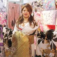 Young women preparing to celebrate Coming-of-Age Day on Monday try on kimono similar to those worn by oiran (Edo Period prostitutes), in Kitakyushu on Dec. 20. | KYODO