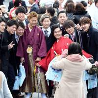 A group of young men pose for a photo during the Coming-of-Age Day ceremony at Tokyo Disneyland in Urayasu, Chiba Prefecture, on Monday. Japan's newest adults ponder politics on Coming-of-Age Day