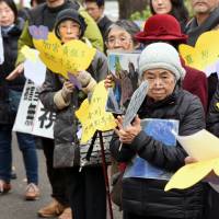 Supporters holding portraits of former “comfort women” rally in front of the Foreign Ministry on Wednesday. Protesters in Tokyo denounce 'comfort women' deal