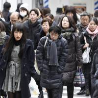 Pedestrians brave the cold Saturday in the Umeda district of Osaka. | KYODO