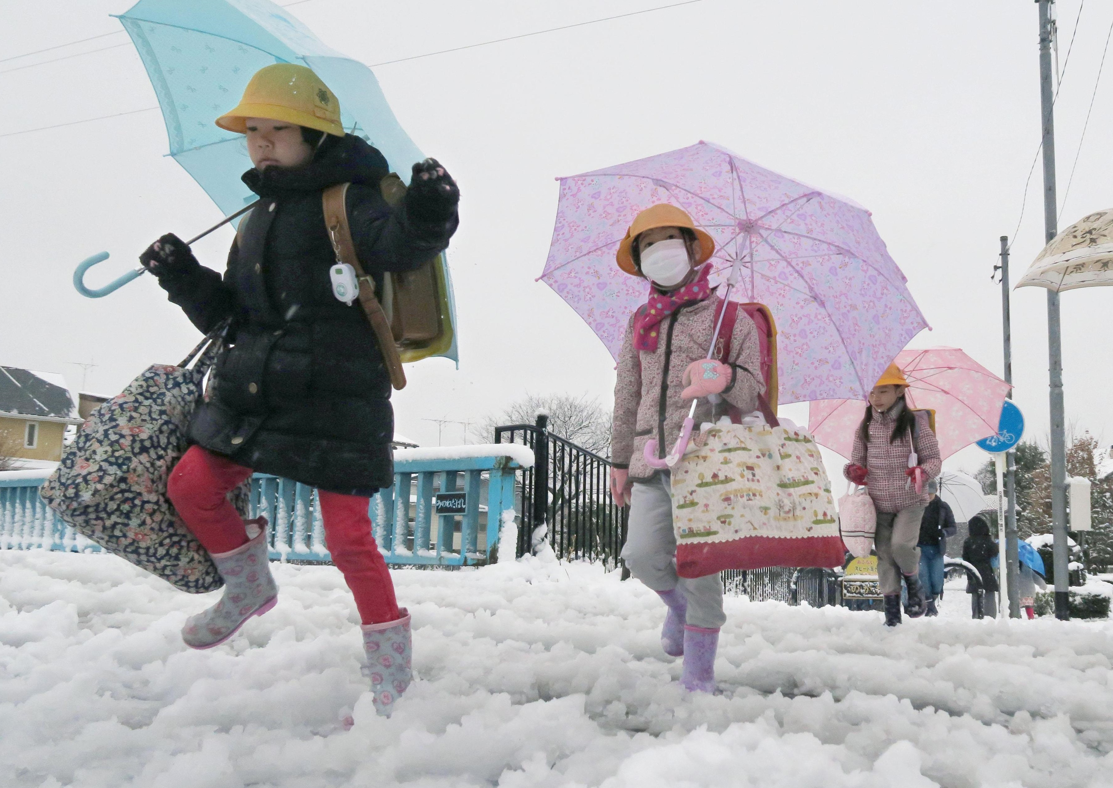 Children walk to school amid heavy snowfall in Chofu, western Tokyo, on Monday morning. | KYODO