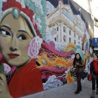 Women walk past a mural in San Francisco’s Chinatown. Step into San Francisco's lively Chinatown