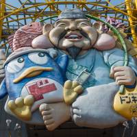 Ebisu, the god of commerce, looks down on Dotonbori’s canal from a giant duty free shop. Dotonbori: Where Osakans eat, drink and be merry