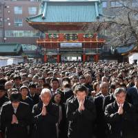 Pray for fortune: People pray on Jan. 4, the first business day of the year, at Kanda Myojin Shrine in Tokyo. However, will 2016 bring some of these workers a better work-life balance? | BLOOMBERG