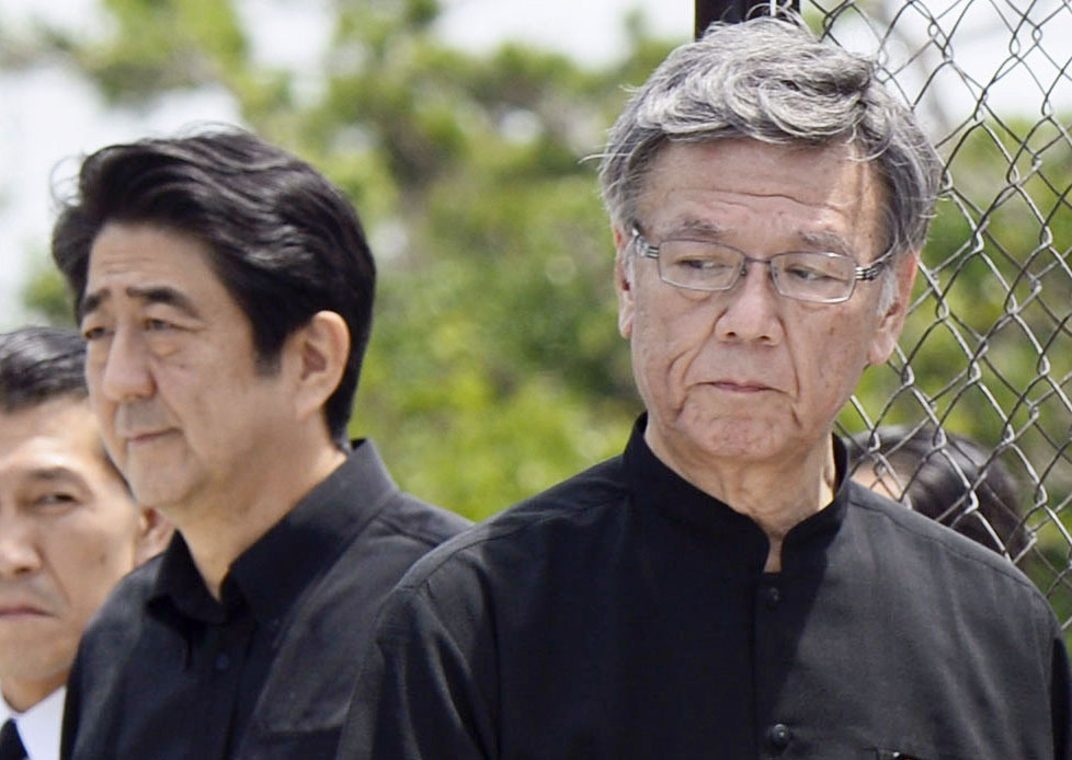 History lessons: Prime Minister Shinzo Abe and Okinawa Gov. Takeshi Onaga pay their respects at the Cornerstone of Peace in Itoman city on June 23 last year, the 70th anniversary of the end of the Battle of Okinawa. | KYODO