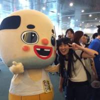 Azusa Matsuda, Society for the Promotion of Japanese Animation\'s director of industry relations poses with the Japanese character Chitchai Ossan at an Anime Expo. | UPRIGHT