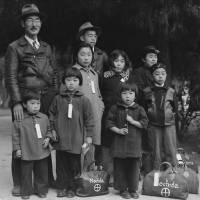 Grave Injustice:  Members of the Mochida family awaiting an evacuation bus in Hayward, California, May, 1942. ID tags were used to aid in keeping the family unit intact during all phases of the evacuation. | WIKICOMMONS