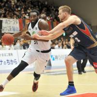Ryukyu big man Evan Ravenel, seen being defended by Yokohama forward Cory Johnson on Christmas Day, has been a key newcomer for the Western Conference power this season. Golden Kings continue winning tradition